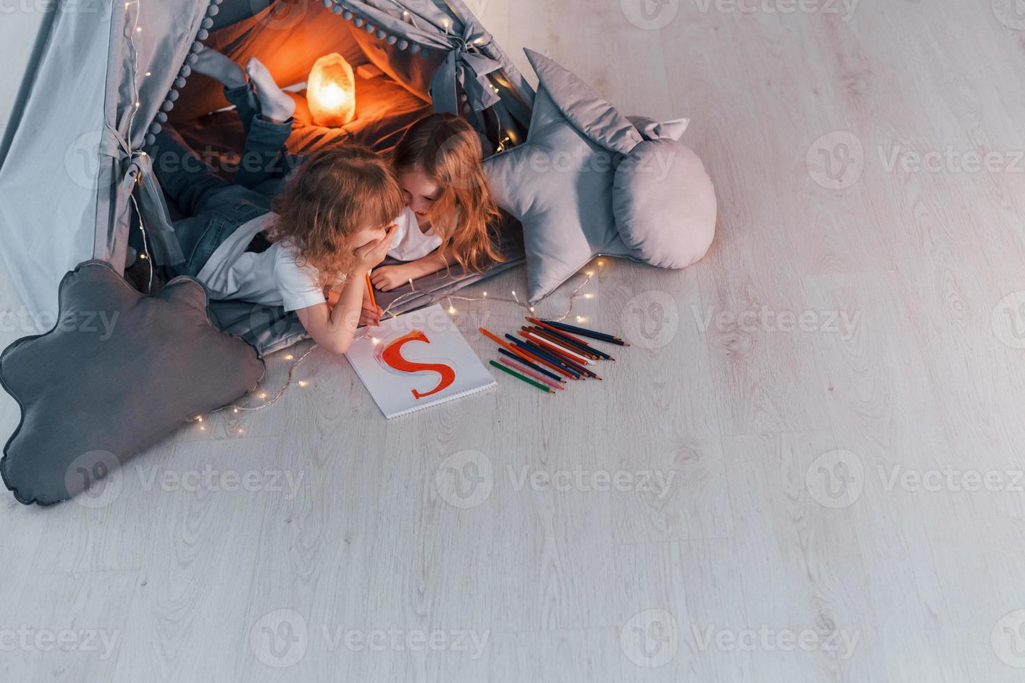 escribiendo una carta. concepción del aprendizaje y la educación. dos niñas pequeñas están juntas en la tienda en la habitación doméstica foto