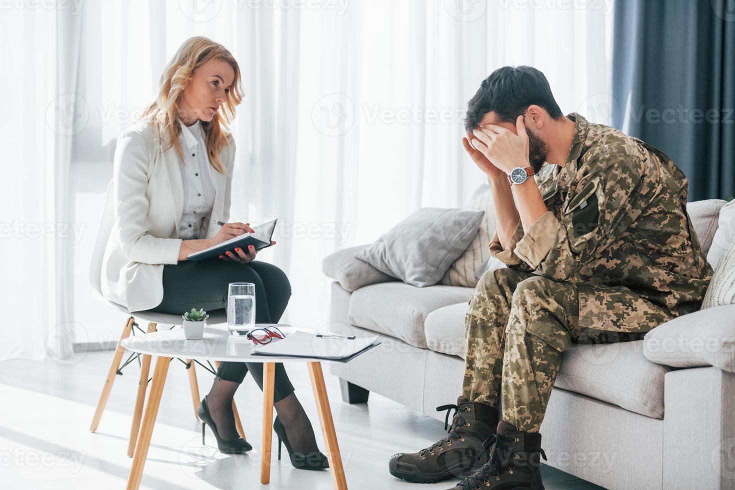 Terrifying memories. Soldier have therapy session with psychologist indoors photo