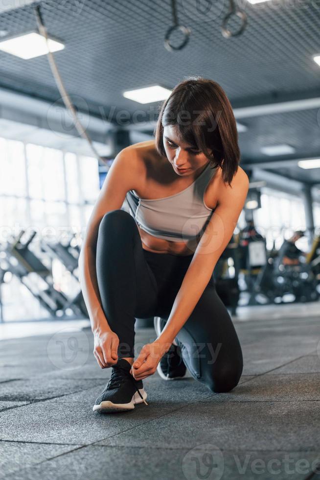 Woman in sportive clothes with slim body type is in the gym