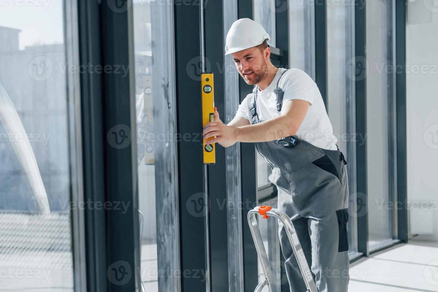 With leader near windows. Repairman is working indoors in the modern room photo
