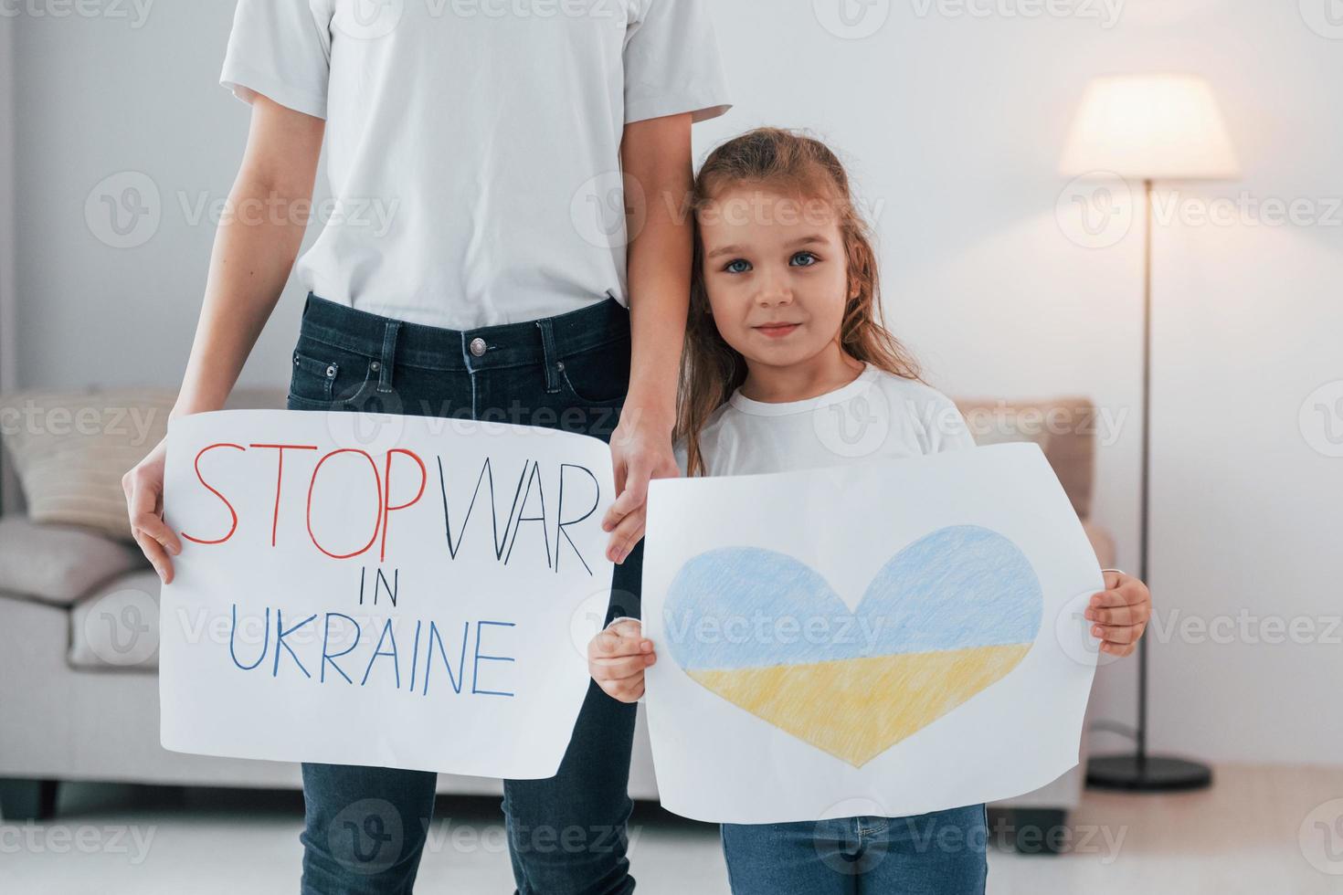 Mother with her little daughter standing with banners with text stop war in Ukrane photo