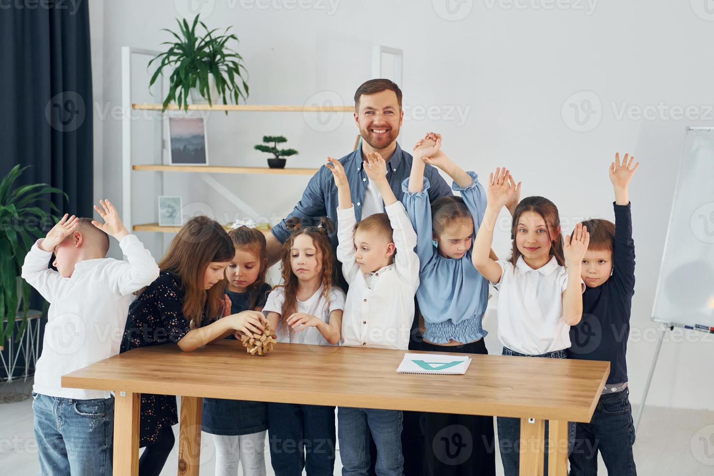 Standing and posing. Smiling together. Group of children students in class at school with teacher photo