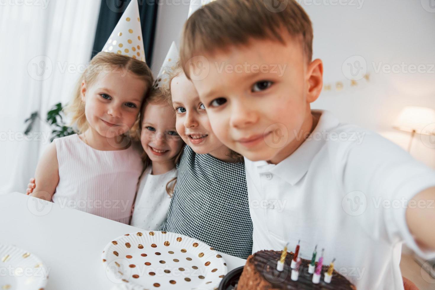 With cake. Making selfie. Celebrating brithday. Group of children is together at home at daytime photo