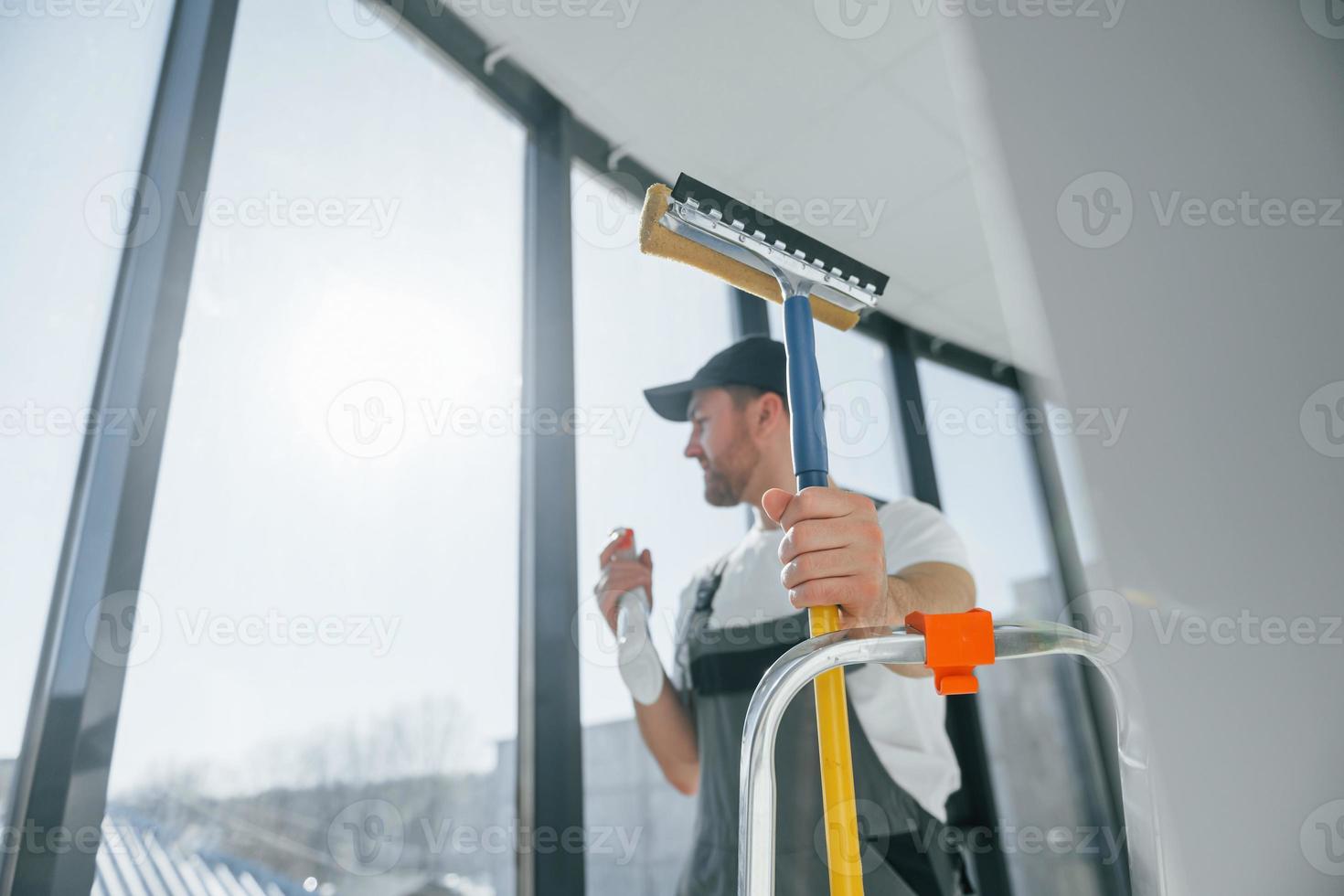 Cleaning service. Repairman is working indoors in the modern room photo