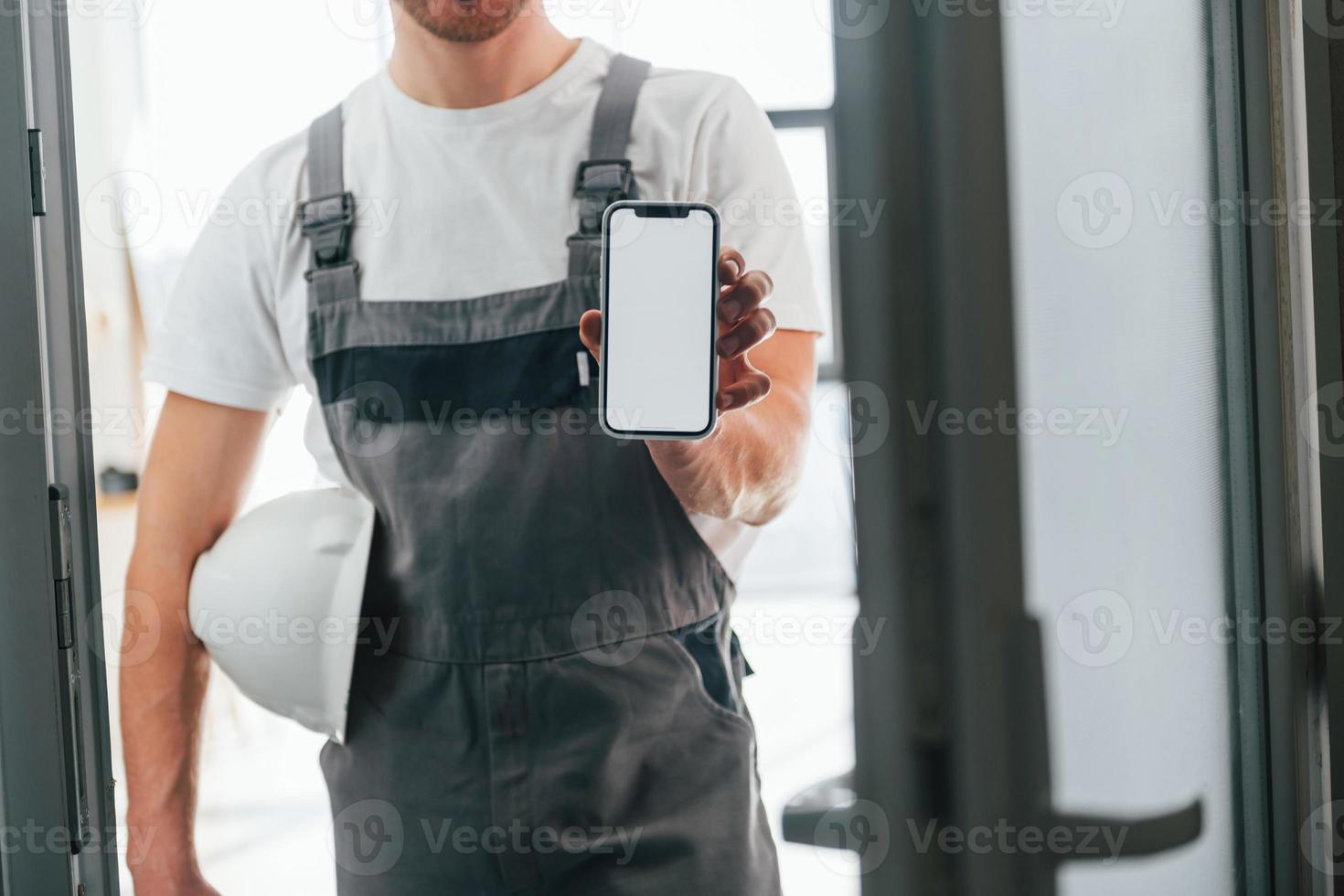 Repairman is standing indoors in the modern room photo