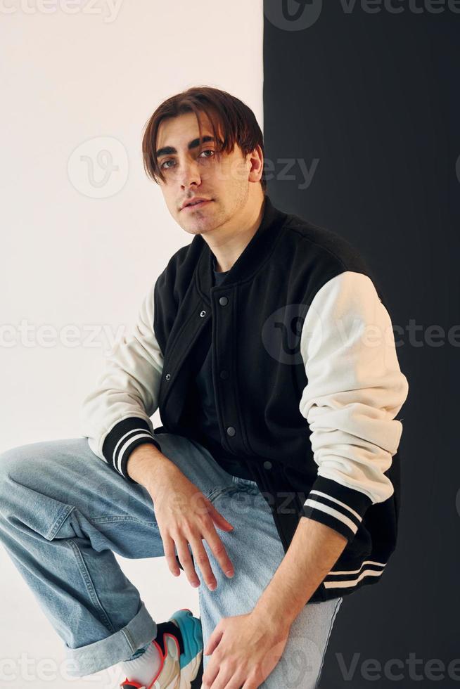 Young man is in the studio with white and black walls photo