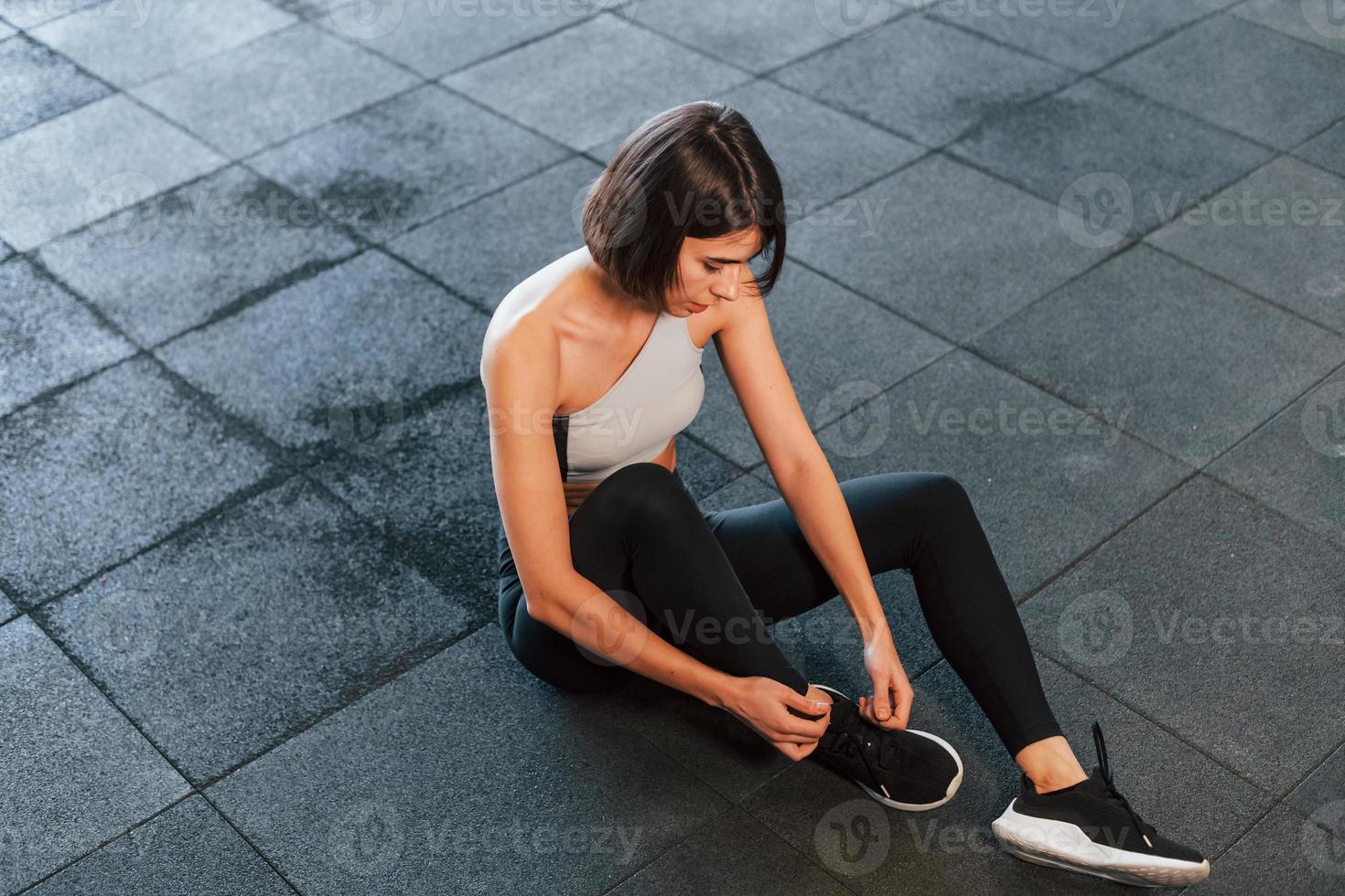 Woman in sportive clothes with slim body type is in the gym