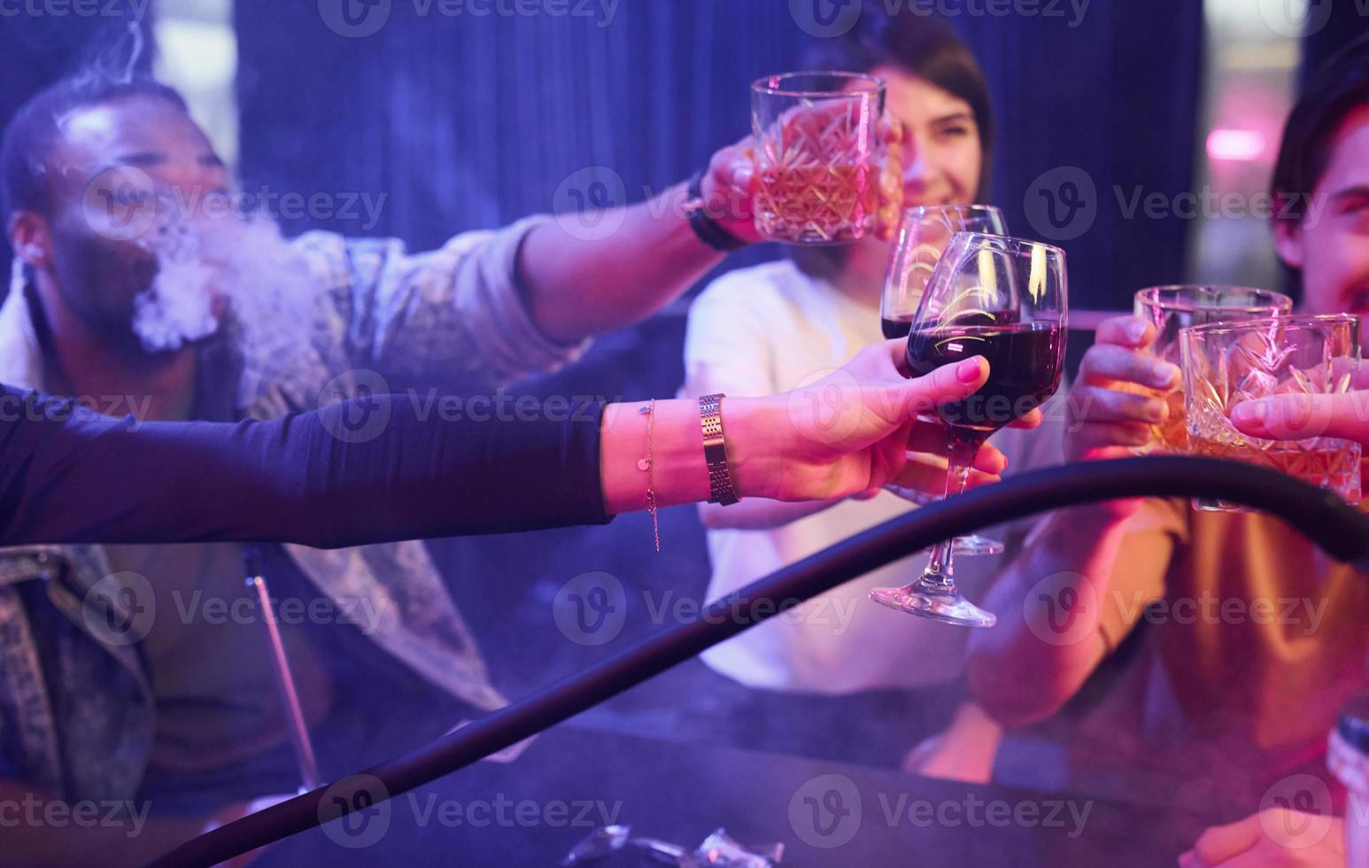 Talking with each other. Group of friends having fun in the night club together photo
