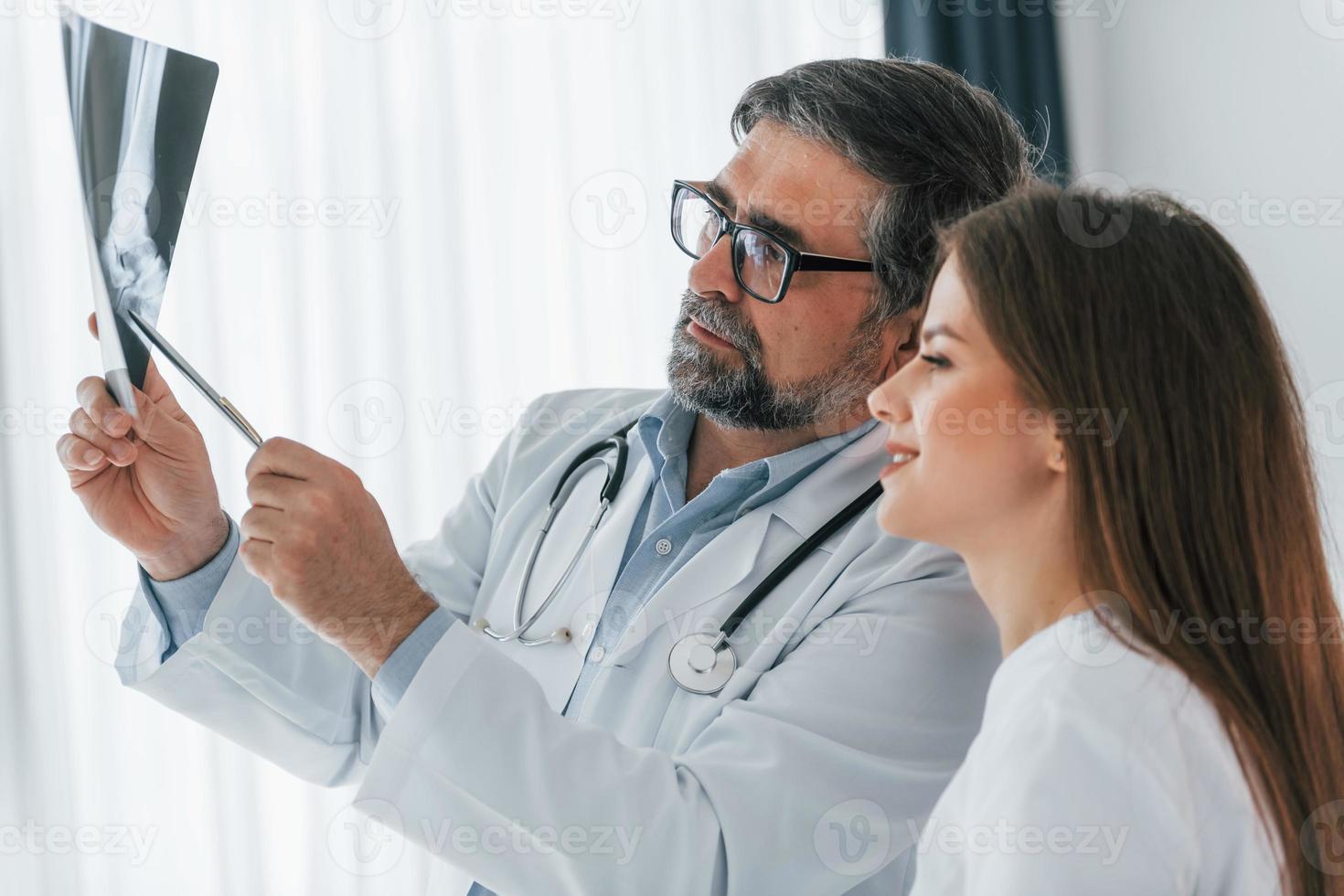 imagen traumática en la radiografía. trabajadores médicos profesionales en batas blancas están en la oficina foto