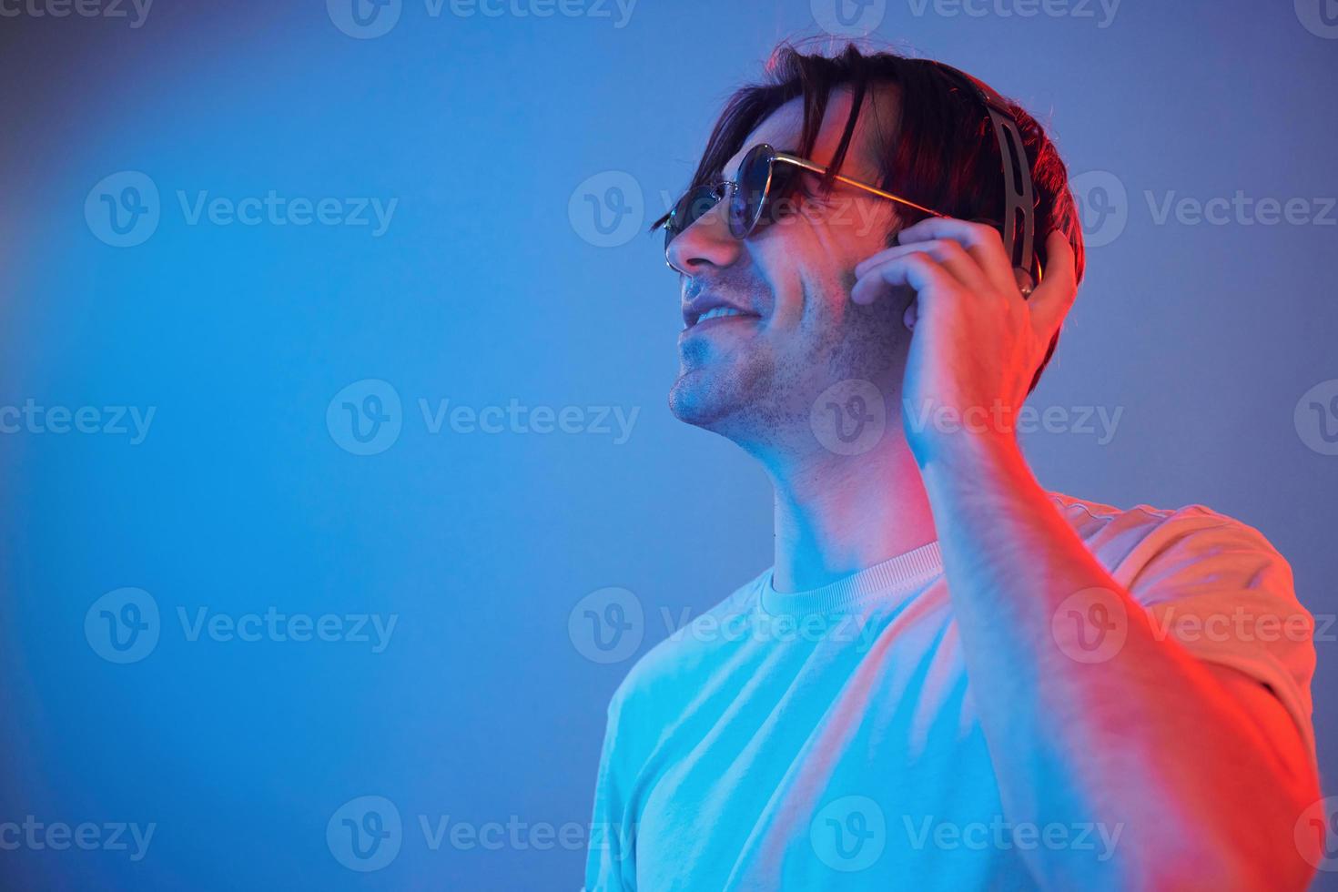 Side view. Man standing in the studio with neon light photo