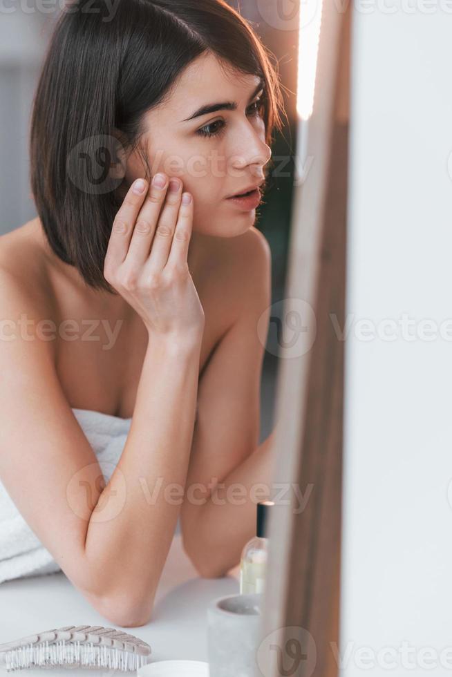 Clean skin. Young woman is at home. Conception of beauty photo