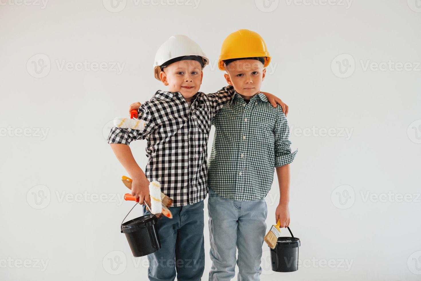 Conception of renewal. Two boys painting walls in the domestic room photo