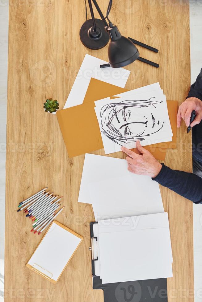 Top view of painter that working on the sketch of a man photo