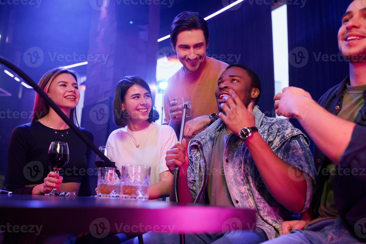 Positive emotions. Group of friends having fun in the night club together photo