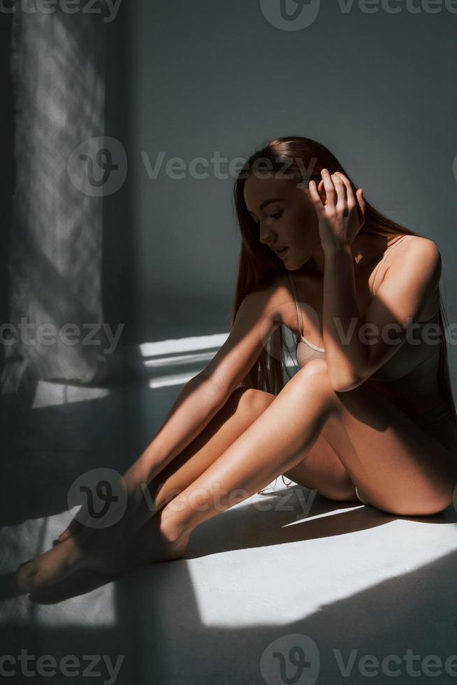 Enjoying sunlight. Woman in underwear with slim body type is posing in the studio photo