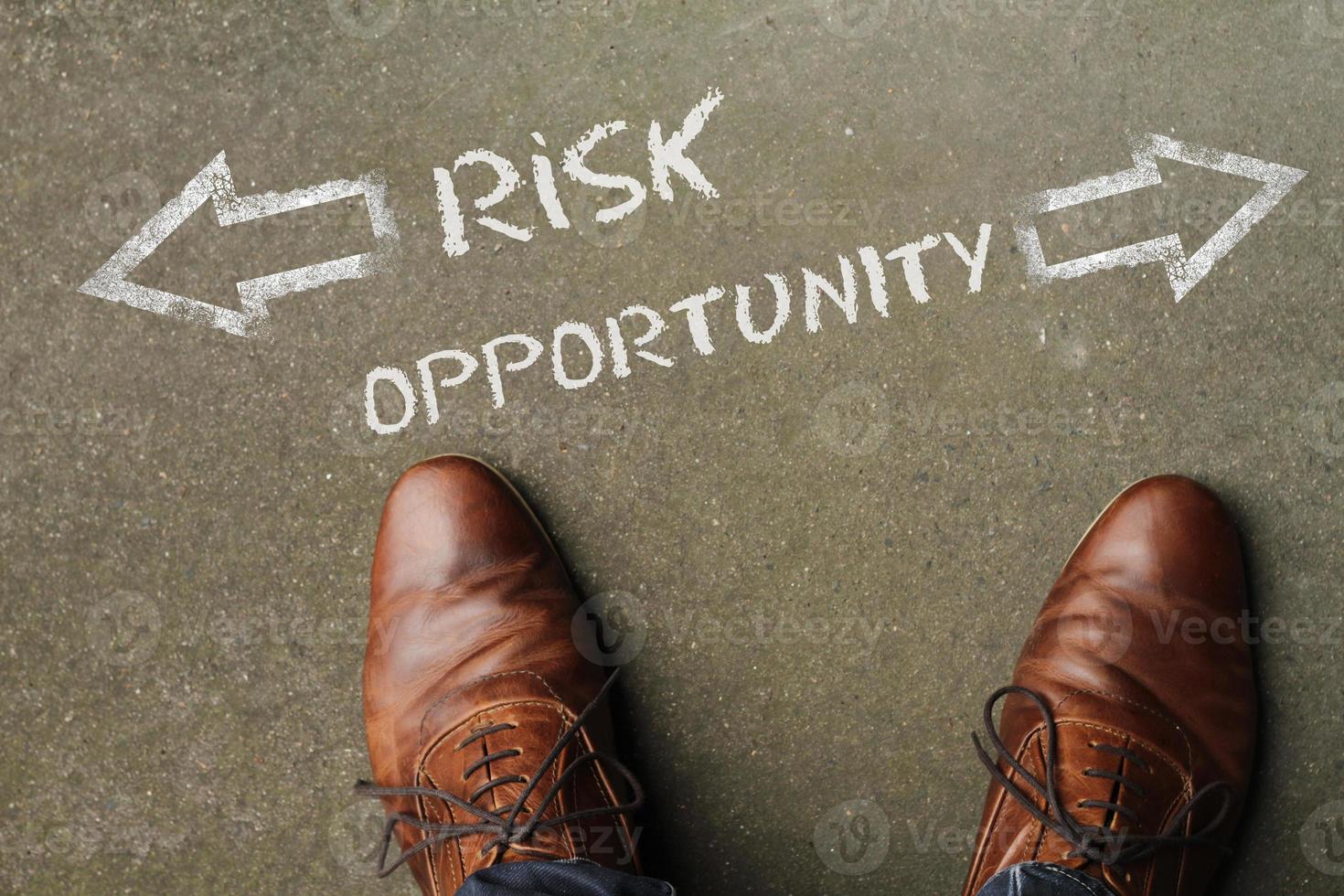 Top view on a man standing in front of the words Risk and Opportunity with arrows pointing to the left and right side of the picture photo