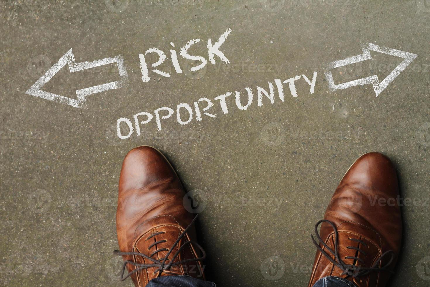 Top view on a man standing in front of the words Risk and Opportunity with arrows pointing to the left and right side of the picture photo