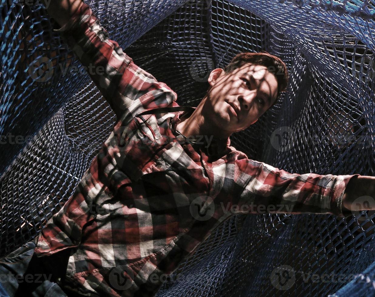 Entangled - a man spreads his arm in a net photo