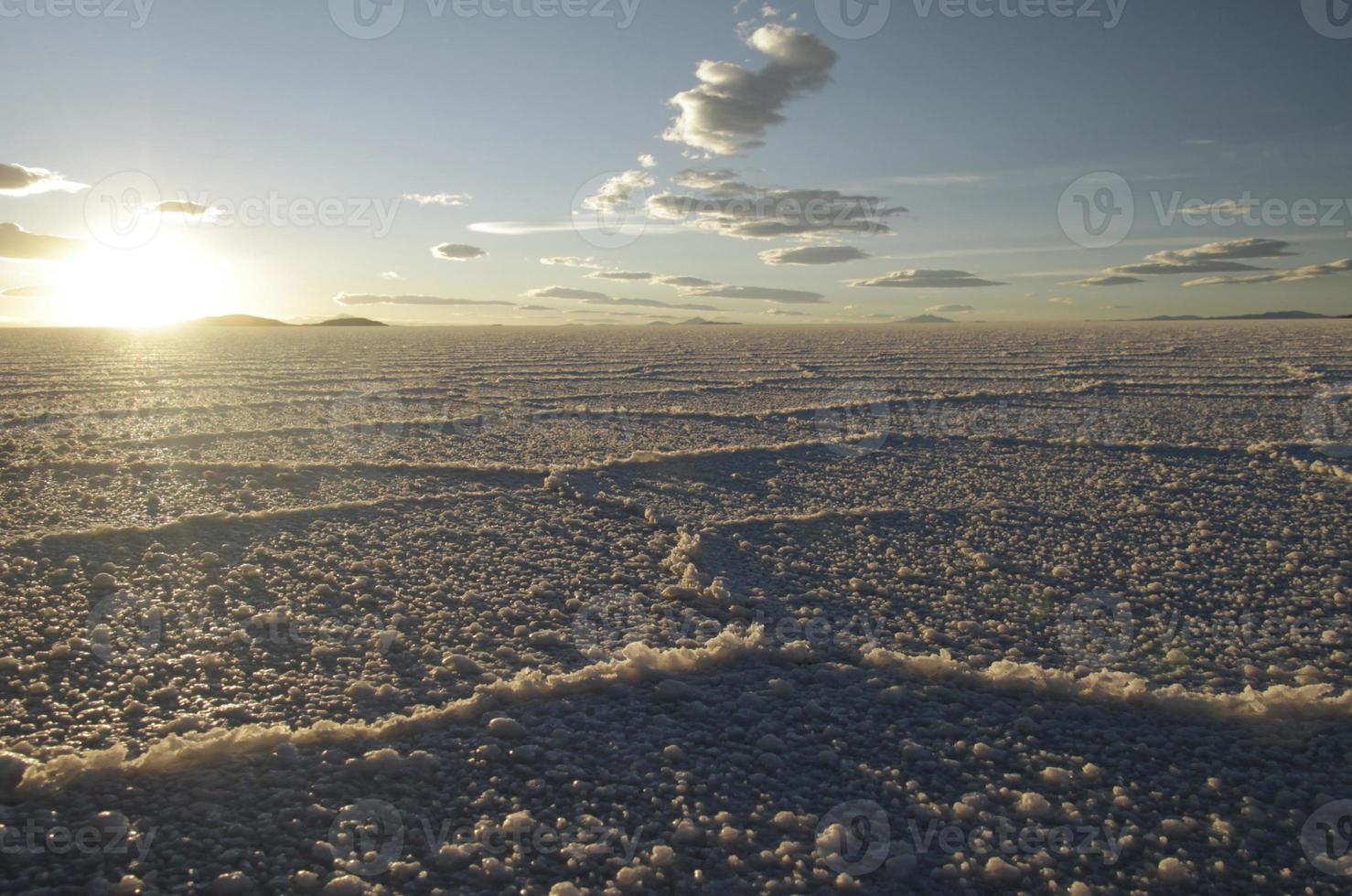 Gorgeous patterns on the surface of the salt flats of Salar de Uyuni, Bolivia, during sunset photo