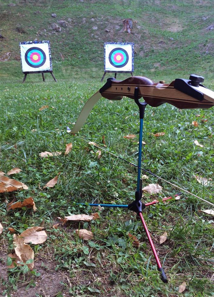 Bow resting on stand with two targets in the background photo