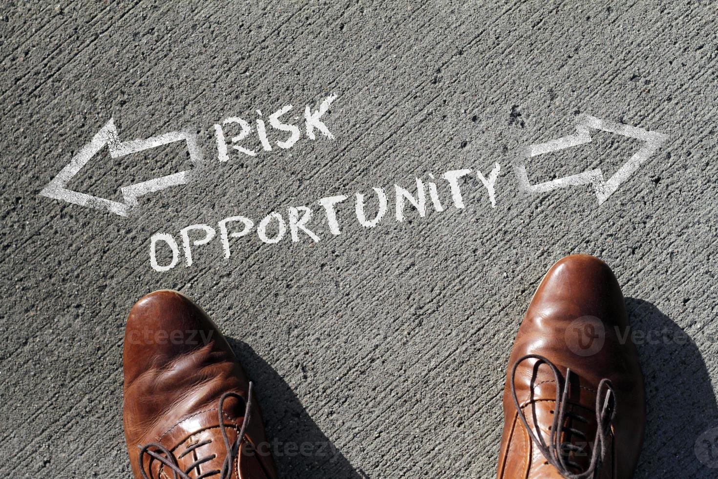 Top view on a man standing in front of the words Risk and Opportunity with arrows pointing to the left and right side of the picture photo