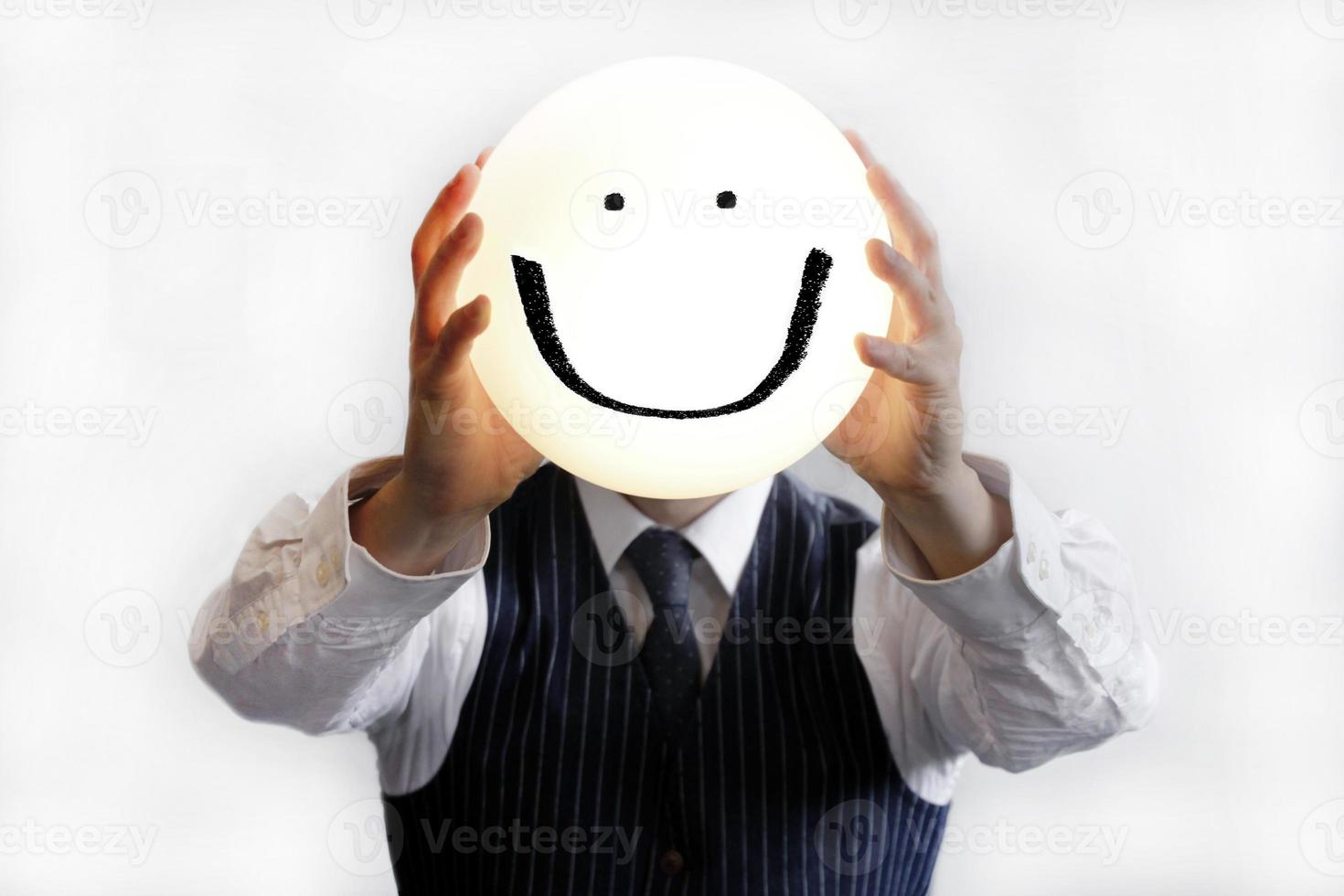hombre de negocios sosteniendo una cara sonriente feliz foto