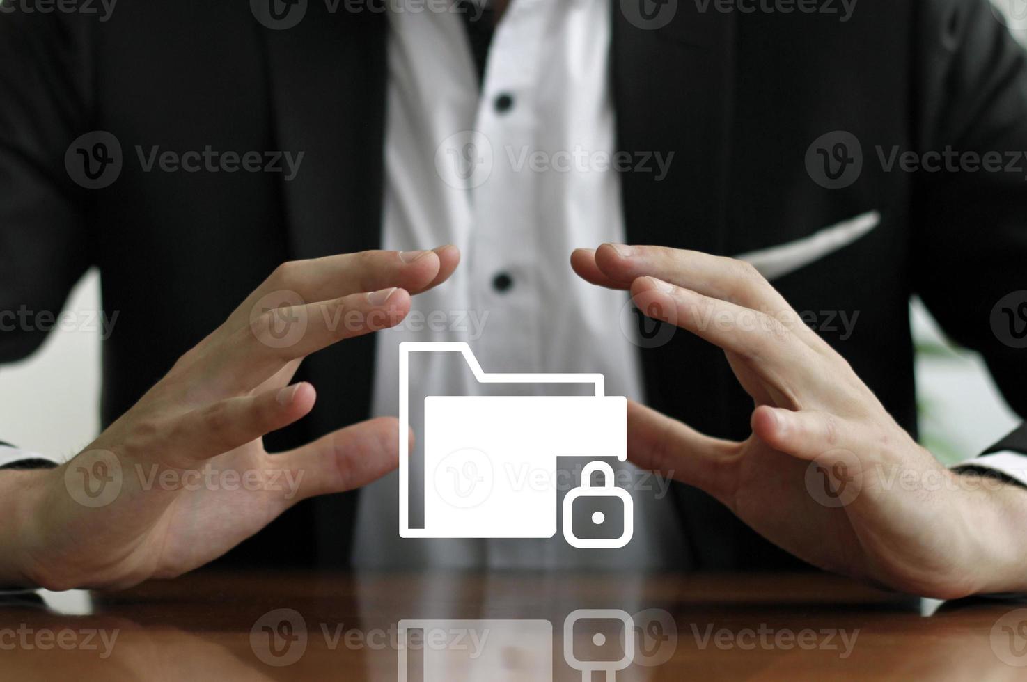 Businessman protecting a secured data folder with his hands photo