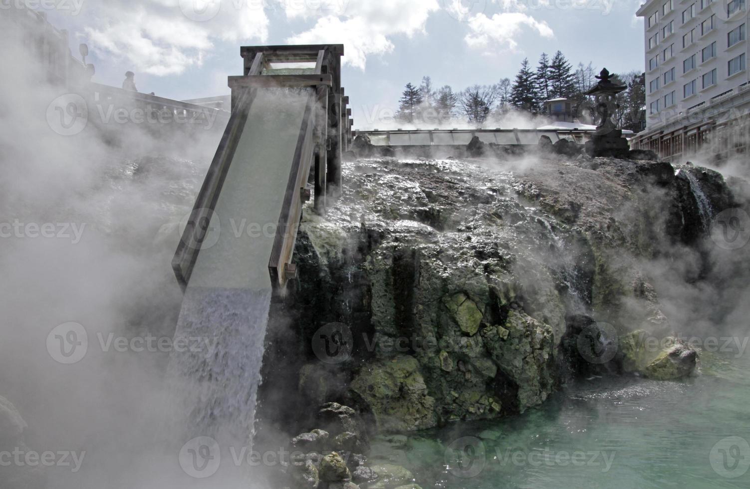 Hot water gushing down a wooden ramp in Kusatsu Onsen in Japan photo