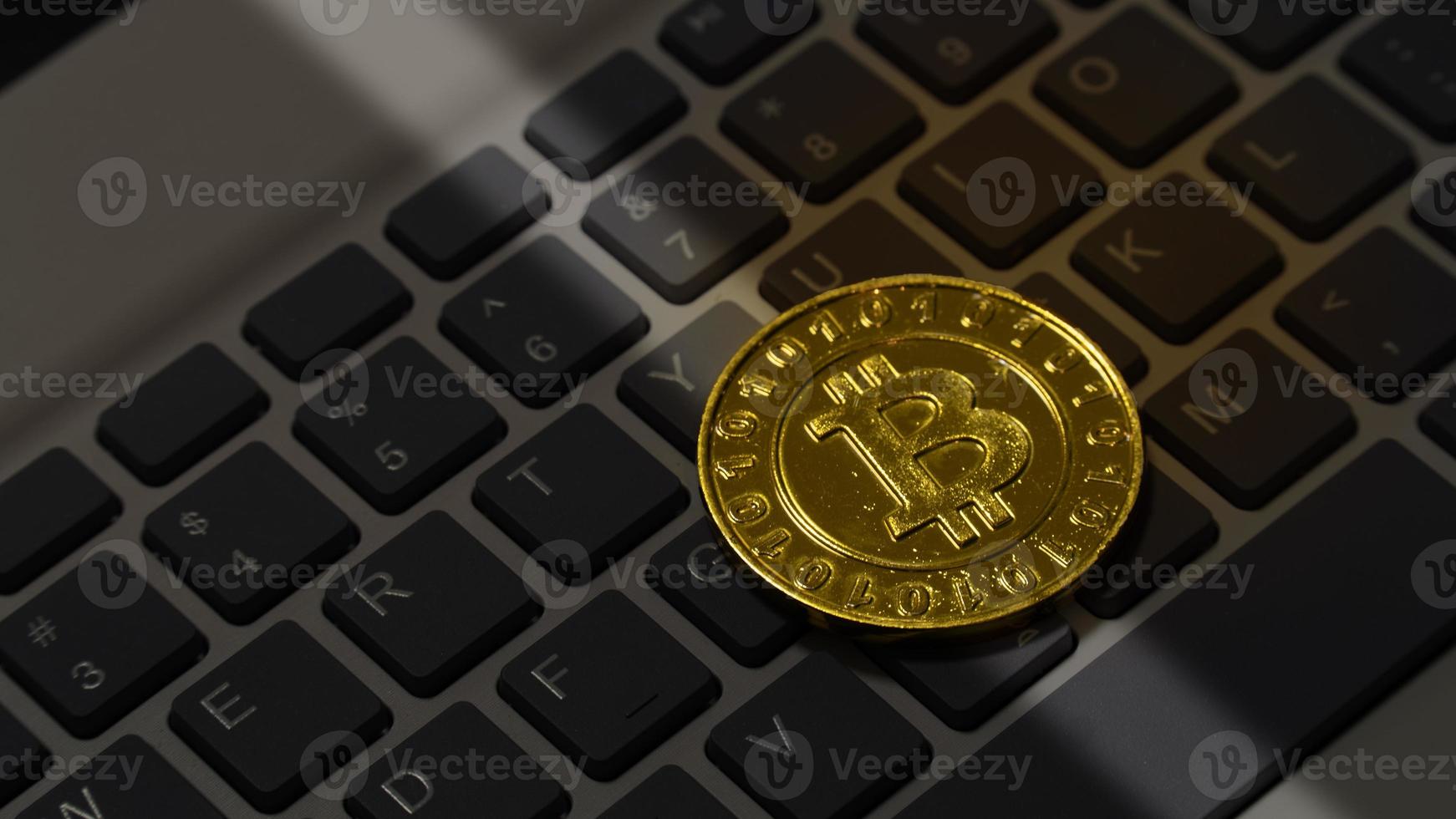 The virtual golden bitcoin money on keyboard laptop computer. photo