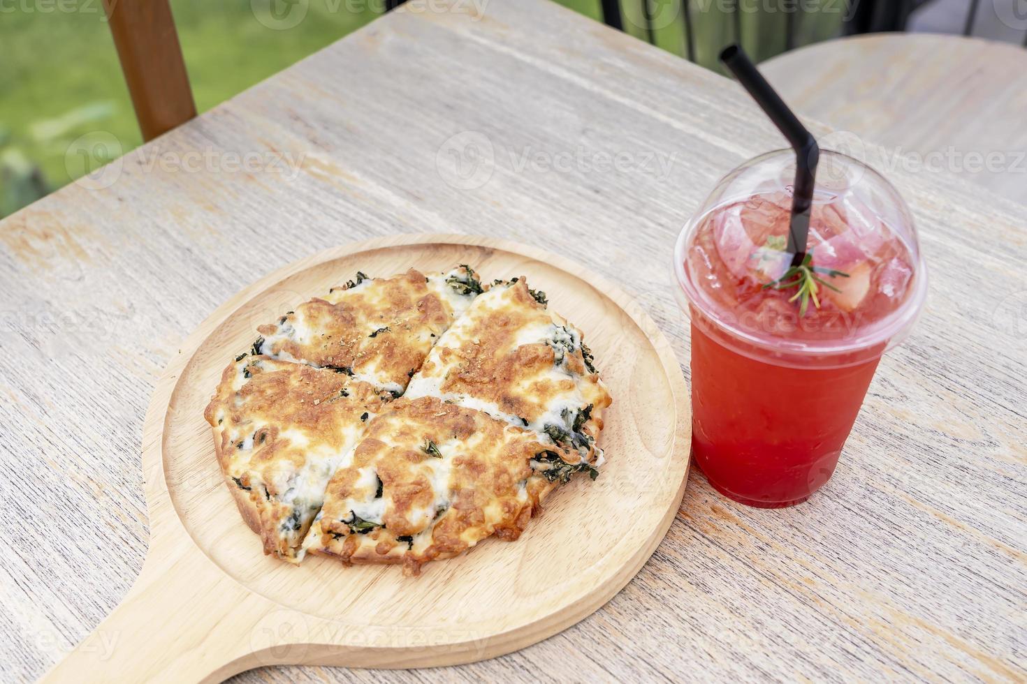 Pizza spinach cheese and ice berry juice in plastic cup that refreshes drinks for summer on table at a cafe. Organic for the healthy and perfect drink for summertime. Holiday and healthy food concept photo