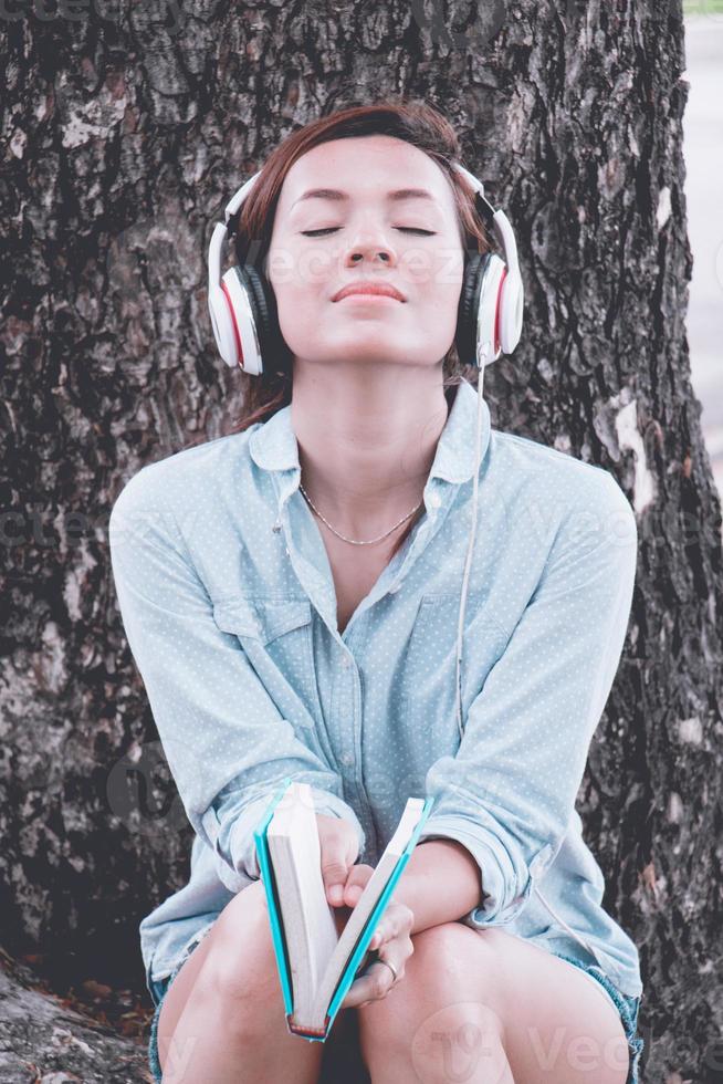 Woman  relax time in park.she sitting under big tree and feel good. she take a deep breath on fresh air. Photo concept relax time and good health.