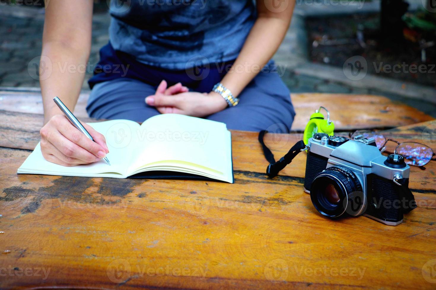 body part. In the morning a women sitting and writing on note book  in public park. photo