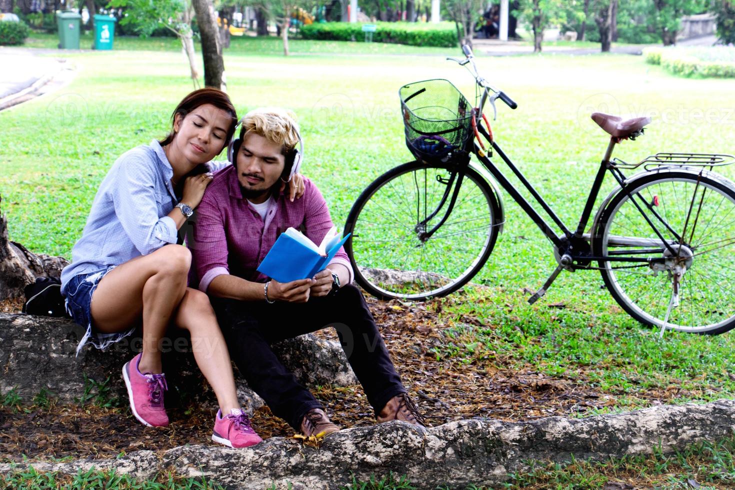 A man read a book and woman read a book too.They are in love and relax time  in public park Thailand.they are honeymoon  day. photo
