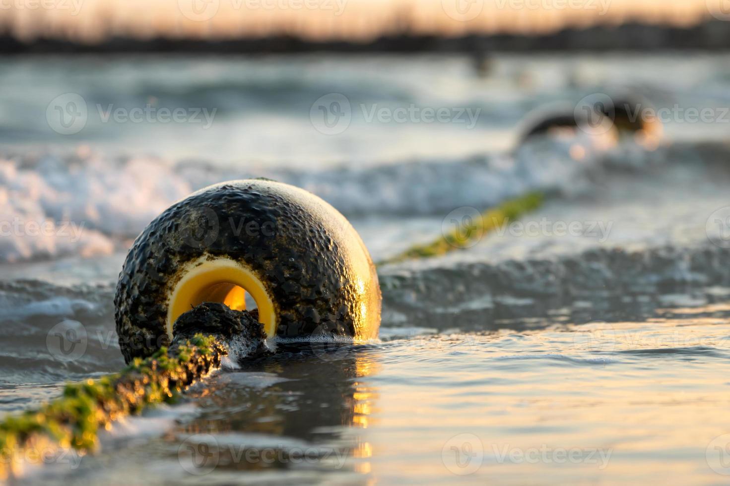 Floating ball buoys that limit safe areas in the water for swimming in summer evening photo