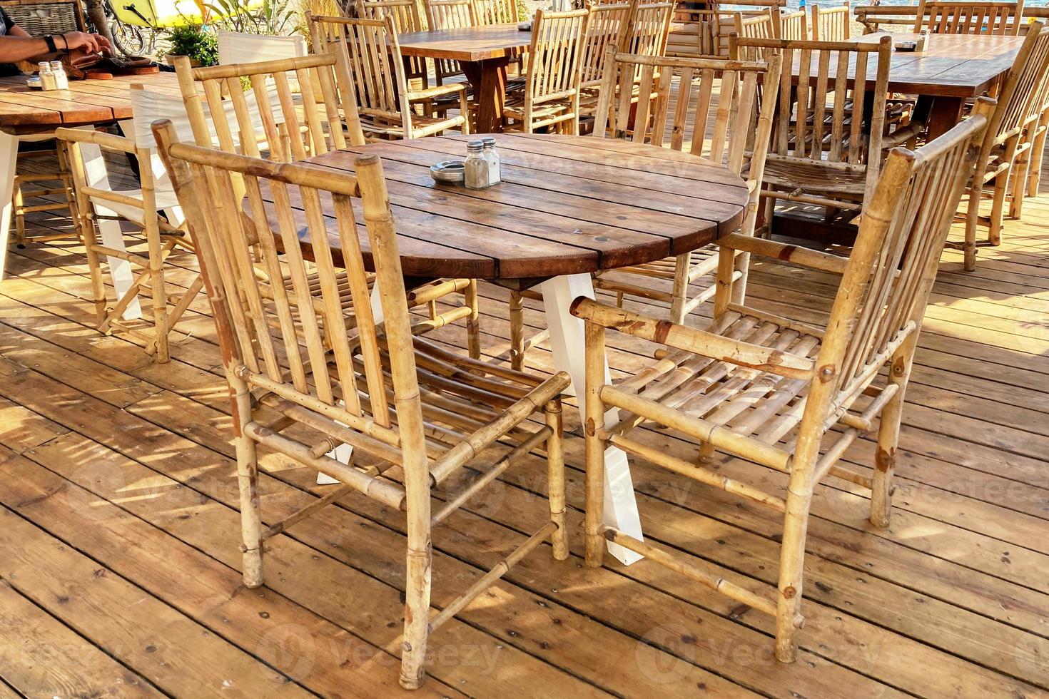 Empty wooden table and chairs in the beach cafe photo