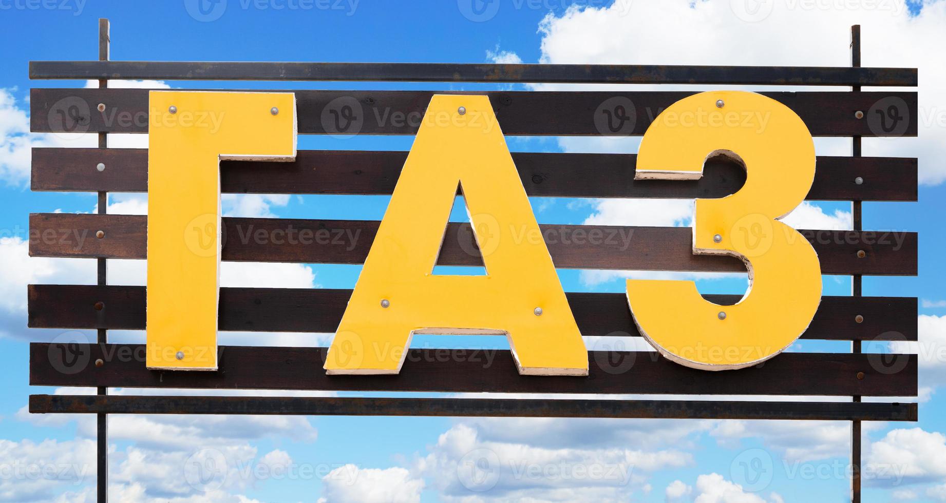 Sign with the word gas written in Russian on the blue cloudy sky background photo