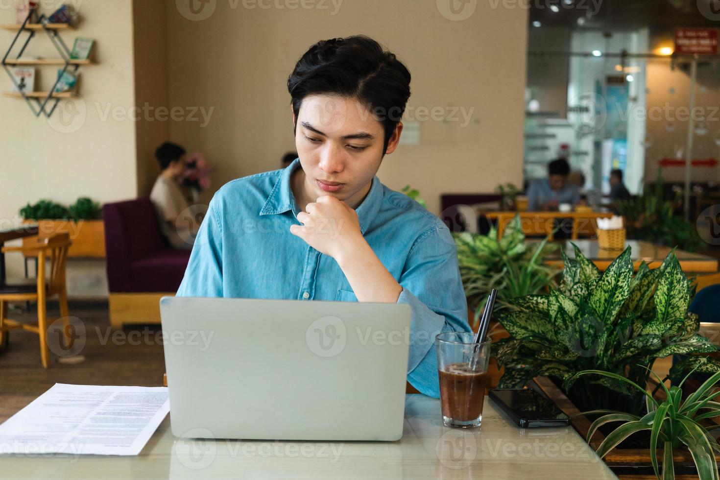 Asian man sitting and drinking coffee photo