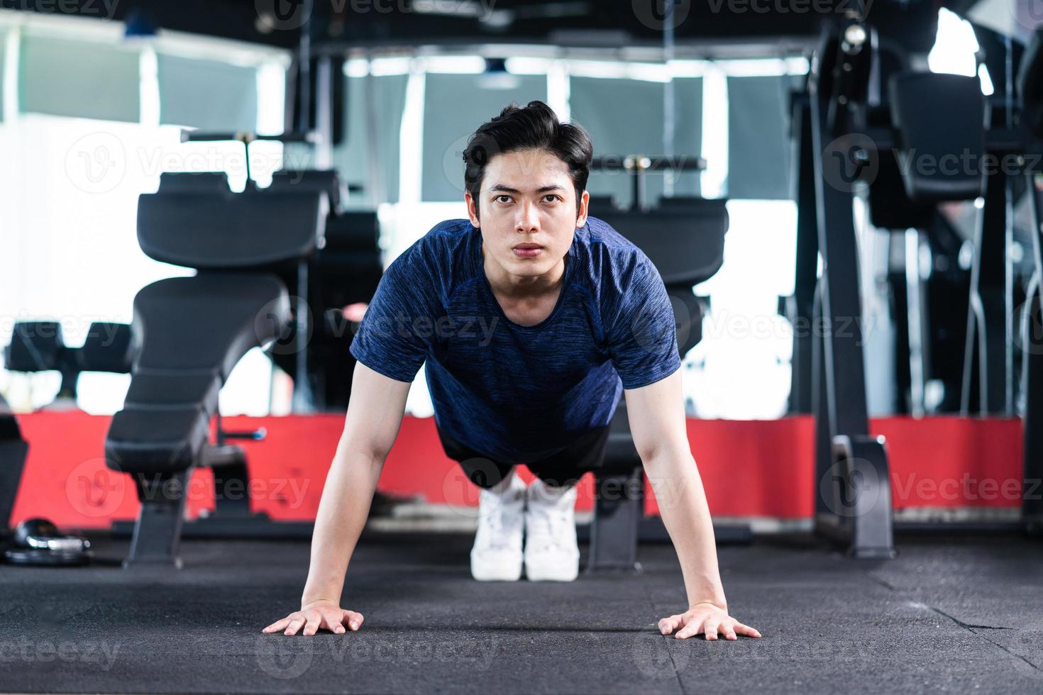 joven en ropa deportiva haciendo ejercicio en el gimnasio foto