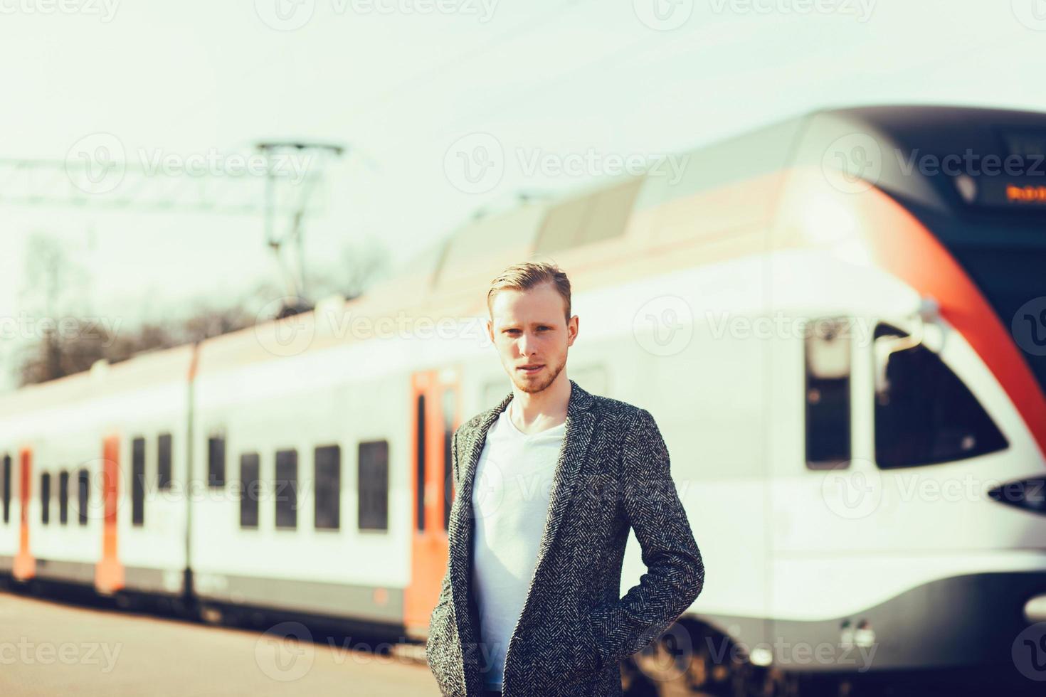 man stands near a modern train photo
