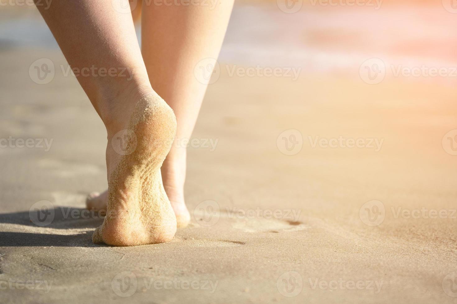 Girl's bare feet on the sea sand close up photo