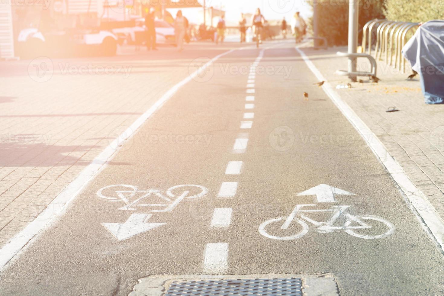 Bicycle path with bicycle road sign on the asphalt on the embankment in Tel Aviv photo