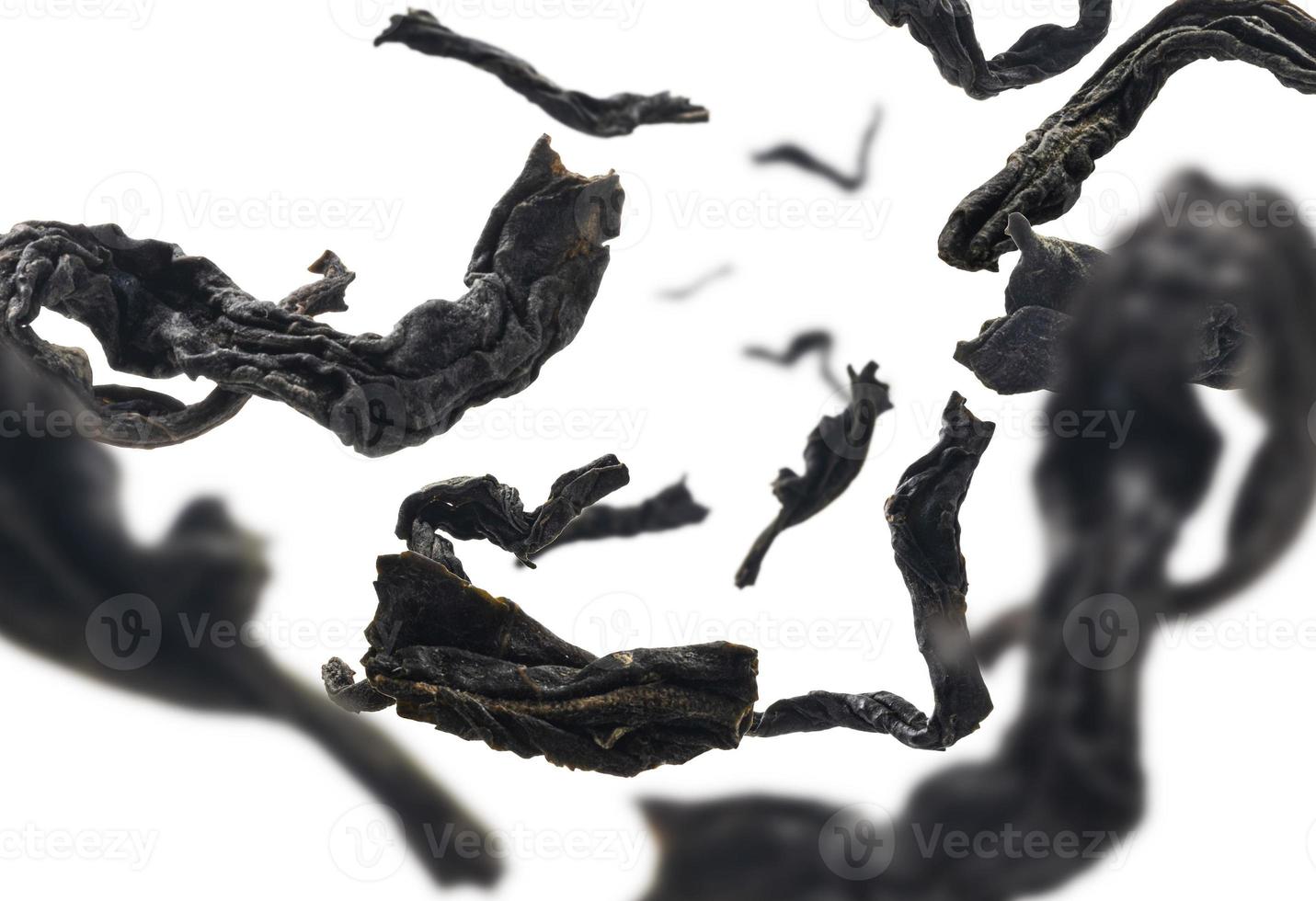 Dried black tea close up levitating on white background photo