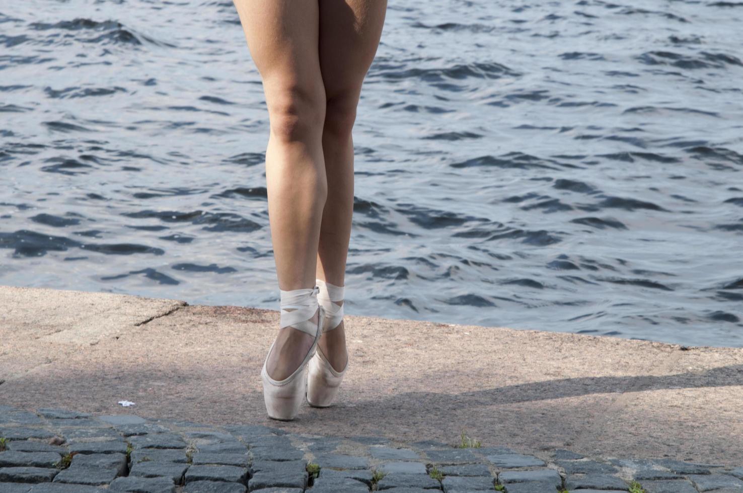 Legs of a female ballet dancer practising on the street with pointe shoes. photo
