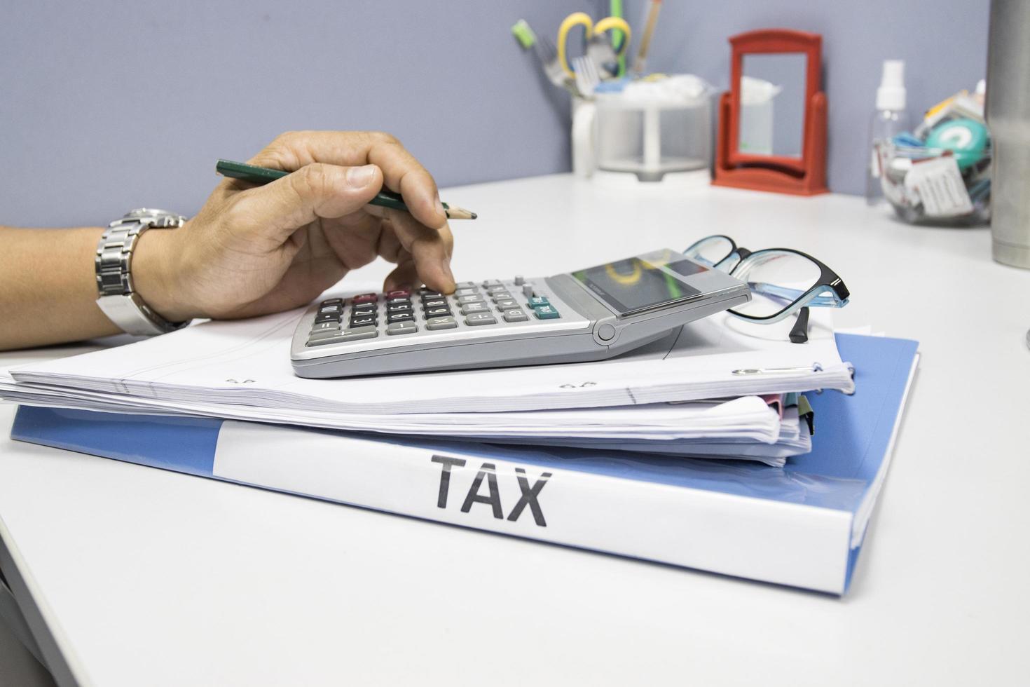 carpeta de documentos fiscales y archivos en papel con el concepto de calculadora pago anual de impuestos foto