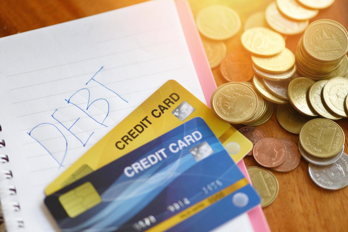 Debt credit card with calculator and coin stack on notebook paper in the office financial counting - debt management concept photo