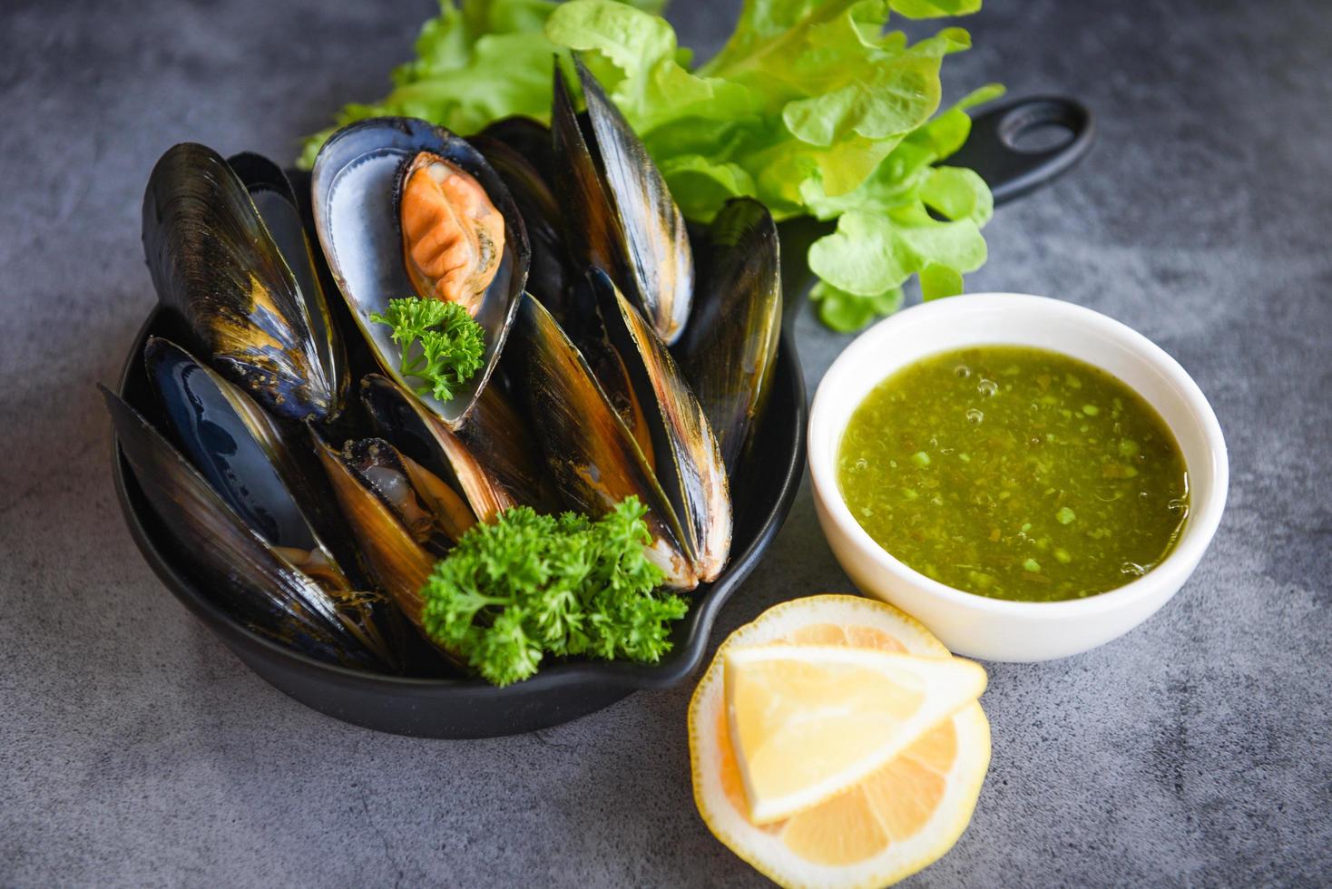 Mussels with herbs lemon on cook steamer food background - Fresh seafood shellfish in the restaurant mussel shell food on pan photo
