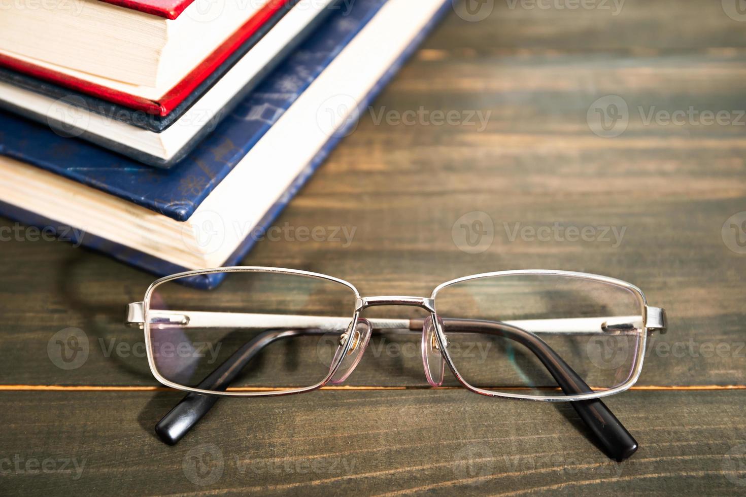 Glasses and stack of hardcover books photo
