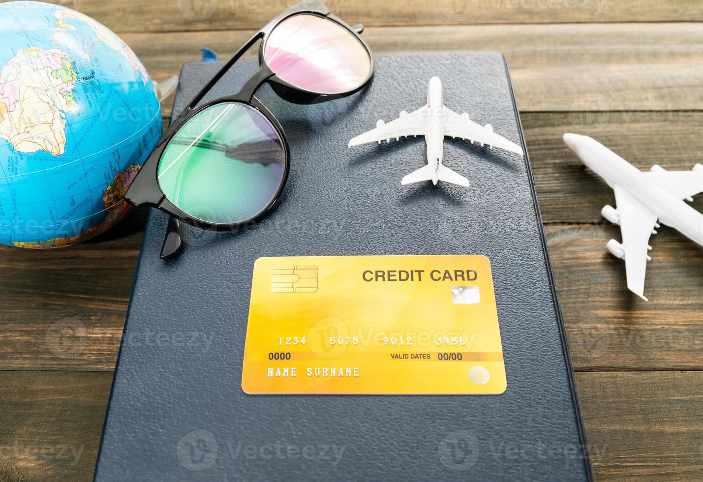 Credit card and airplane model on wooden table photo