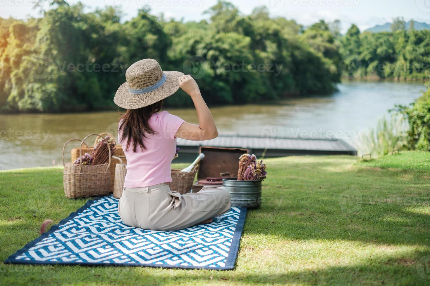 Happy Woman with hat in picnic time in the park near river, Summer, spring and vacation concept photo