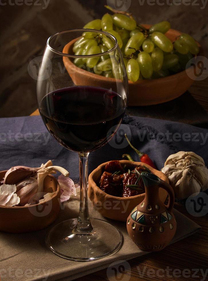 A glass of wine on a table with dishes photo